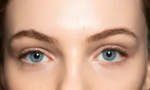 Occhi azzurri luminosi con un trucco leggero che ne esalta la bellezza naturale. Ciglia lunghe e definite.