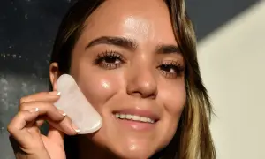 Donna sorridente con pietra gua sha rosa, mostrando un viso radioso e tonico, un effetto gua sha prima e dopo visibile.