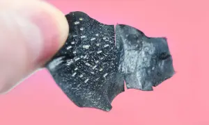 Un dito tiene un pezzo di maschera nera, piena di punti neri rimossi.