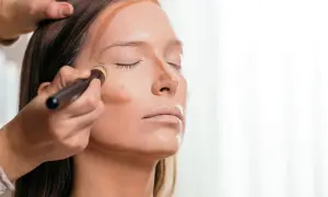 Applicazione di prodotto per lo schema contouring viso con pennello, definendo zigomi e naso.