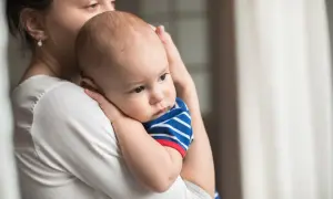 Mamma abbraccia il suo neonato, un piccolo tesoro come grani di miglio, con amore e tenerezza.