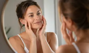 Donna si tocca il viso, ammirando i risultati del botox mento prima e dopo. Pelle liscia e luminosa.
