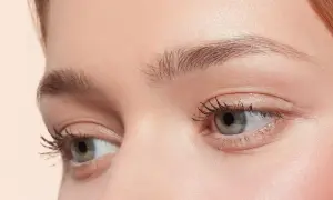 Occhi verdi con ciglia lunghe e folte, sopracciglia curate e un tocco di blush. Un look make up nude che esalta la bellezza naturale.