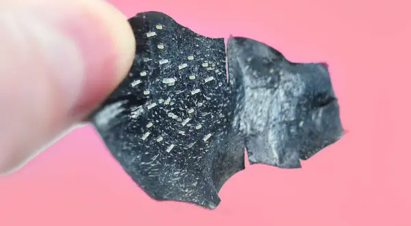 Un dito tiene un pezzo di maschera nera, piena di punti neri rimossi.