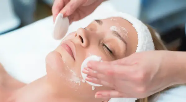 Una donna riceve un trattamento viso. La frequenza ideale per la pulizia del viso dipende dal tipo di pelle e dalle esigenze individuali.