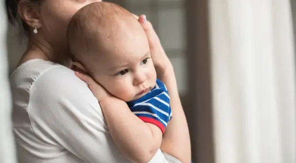 Mamma abbraccia il suo neonato, un piccolo tesoro come grani di miglio, con amore e tenerezza.