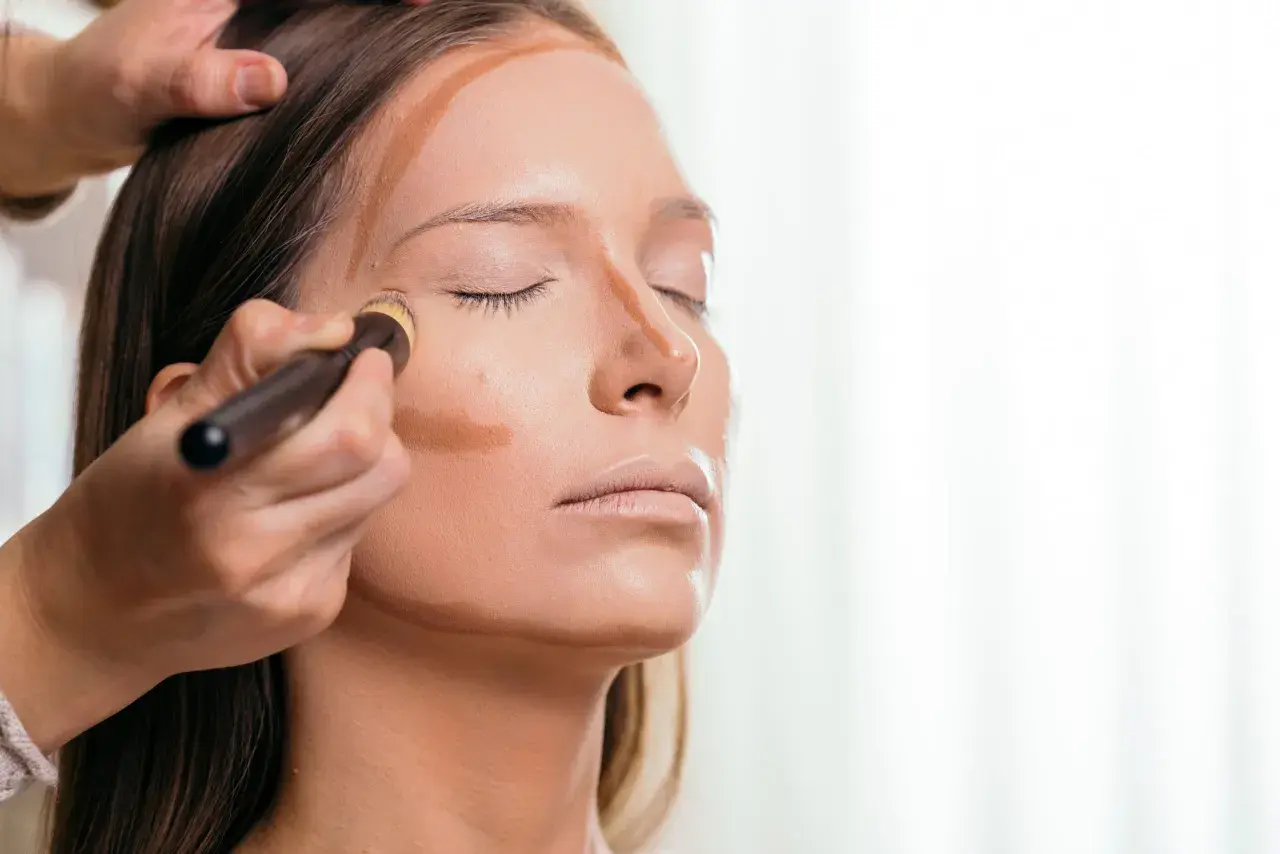 Applicazione di prodotto per lo schema contouring viso con pennello, definendo zigomi e naso.