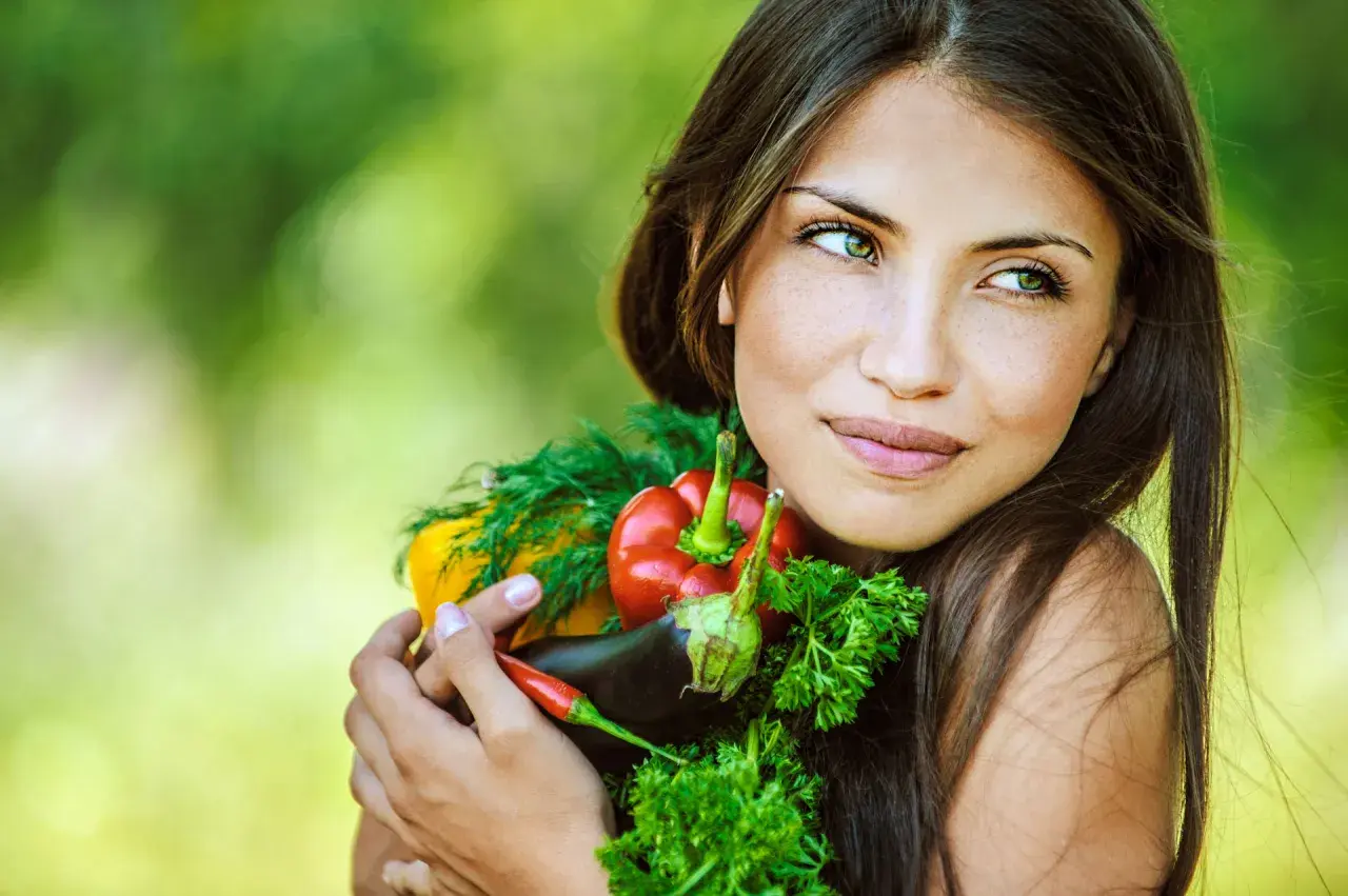 Segreti per come avere una pelle perfetta: una donna abbraccia verdure fresche, simbolo di benessere e bellezza naturale.