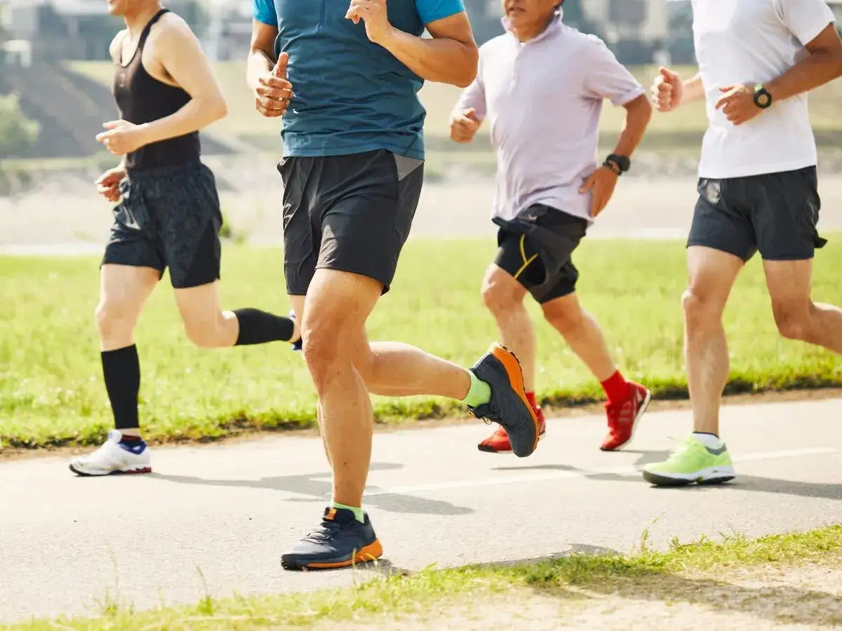 Uomini che corrono all'aperto, un esempio di quanti km correre al giorno per dimagrire e mantenersi in forma.
