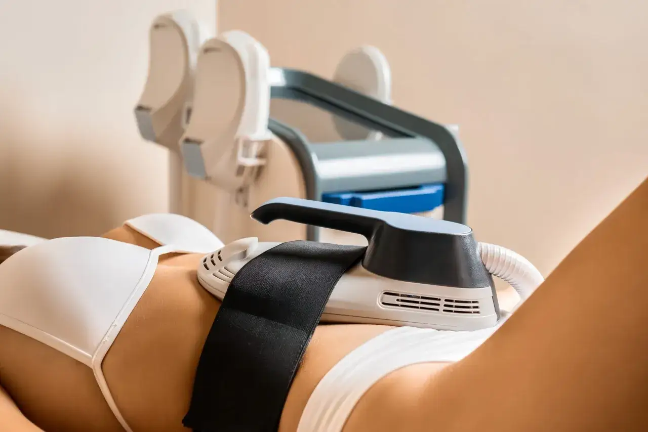 Donna in trattamento estetico con apparecchiatura per rimodellamento corporeo. Opinioni sulla liposuzione non chirurgica.