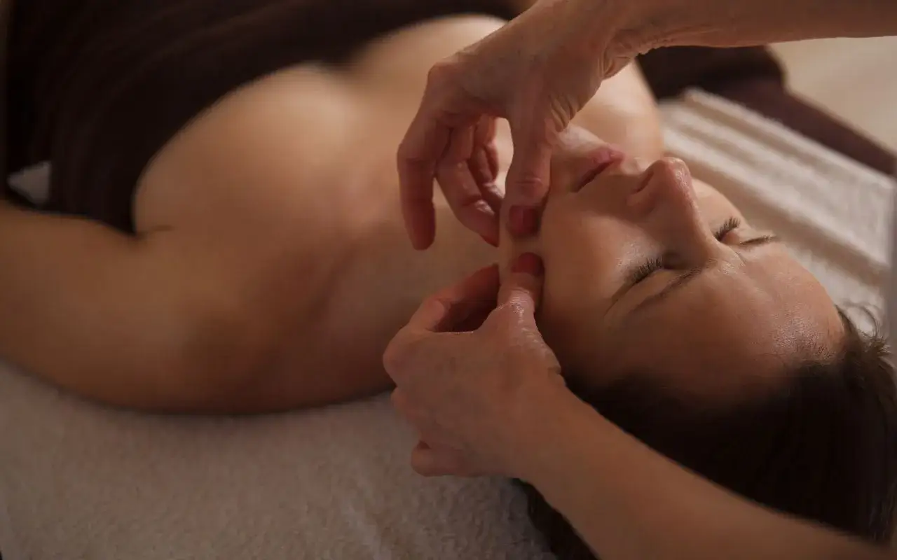 Mani esperte eseguono un delicato massaggio antirughe viso, rilassando i muscoli e donando nuova vitalit&agrave; alla pelle.
