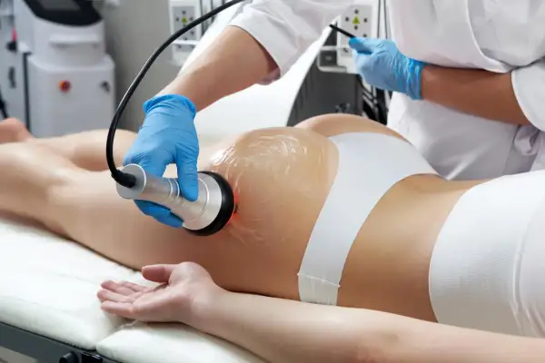 Trattamento estetico con manipolo per sciogliere grasso localizzato su glutei e gambe.