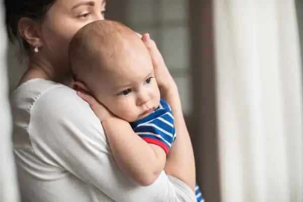 Mamma abbraccia il suo neonato, un piccolo tesoro come grani di miglio, con amore e tenerezza.